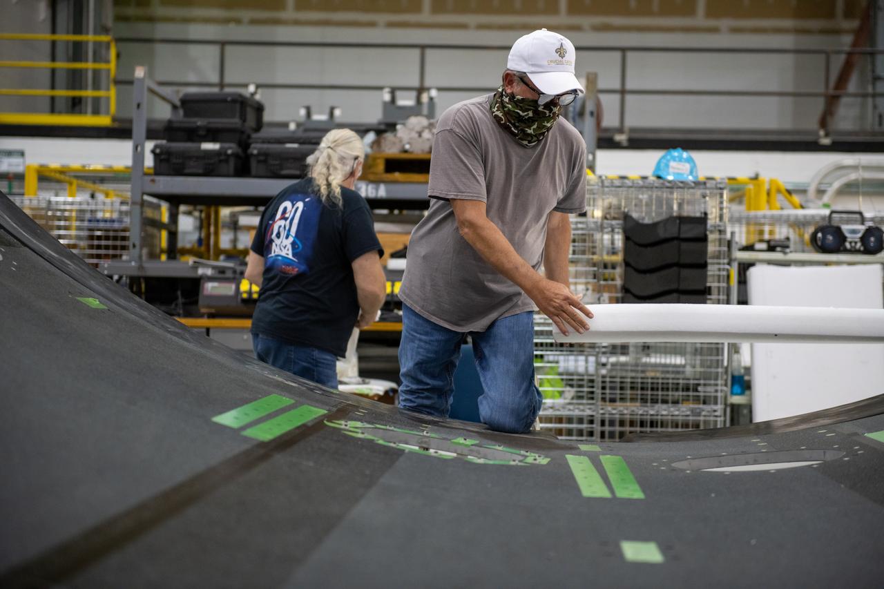 Employees wear personal protective gear at  Michoud Assembly Facility as the facility transitioned to Stage 3 of NASA’s Framework for Return To On-Site Work. Employees wear the appropriate personal protective equipment (PPE) and/or cloth face coverings as required for assigned tasks. Access to the facility is limited to authorized personnel working on mission-critical tasks that must be conducted onsite. Mission-critical tasks include slowly and methodically resuming Space Launch System (SLS) Core Stage and Orion production activities, particularly critical path deliverables to support the Artemis Program, at a pace that limits personnel and follows federal guidelines for social distancing and use of personal protective equipment such as face masks. For more information about SLS, visit nasa.gov/sls.